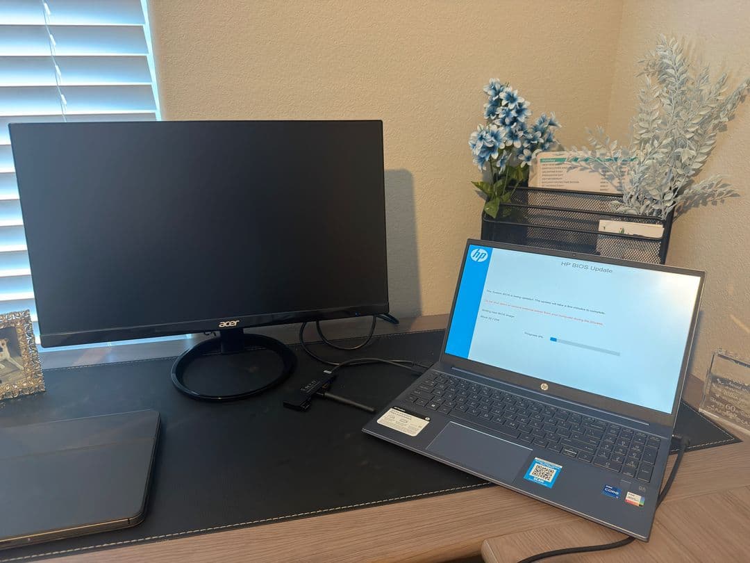 A desk with a monitor and a laptop in window light